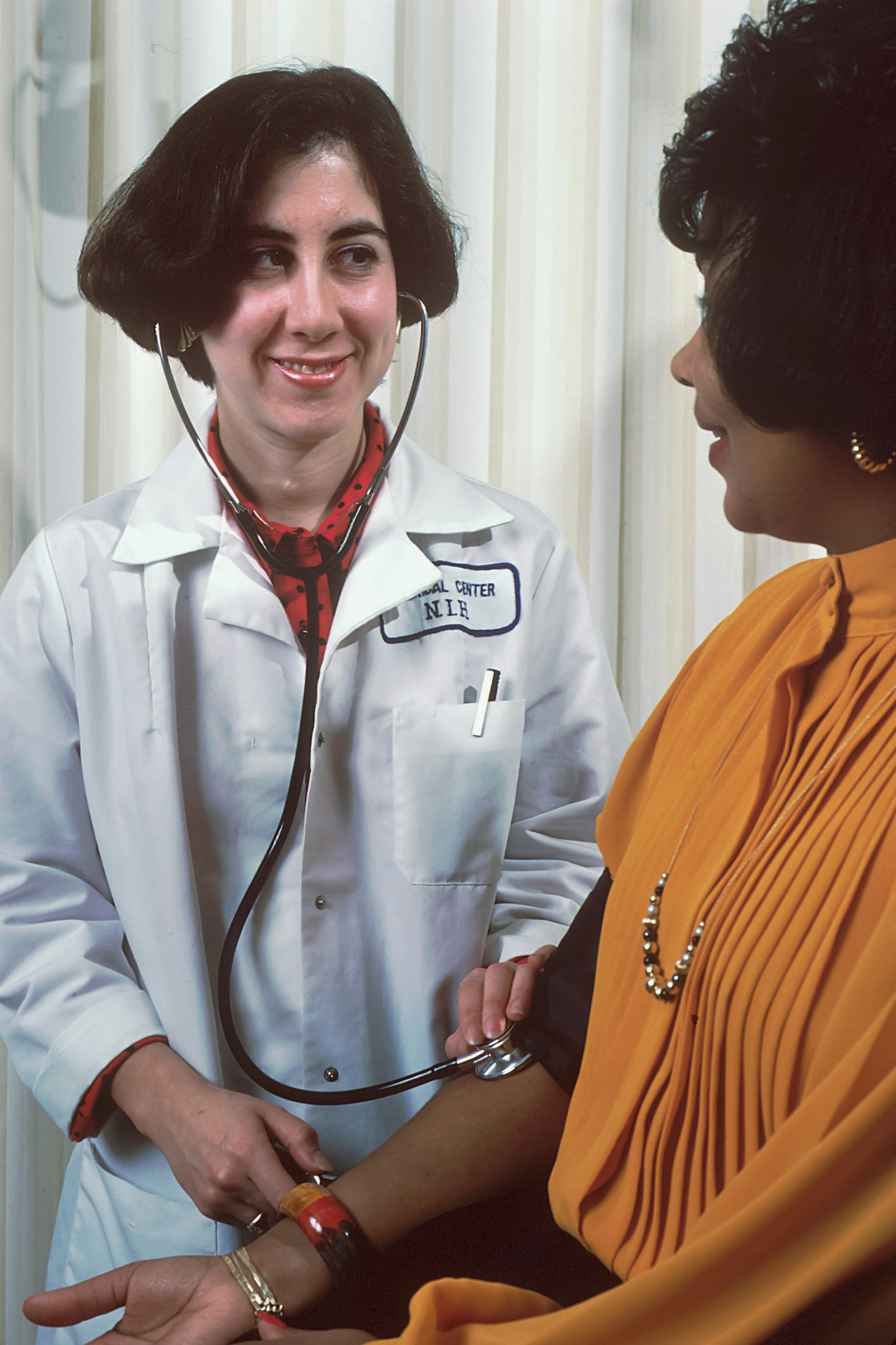 Médica latina conversando com paciente sobre cuidados de saúde